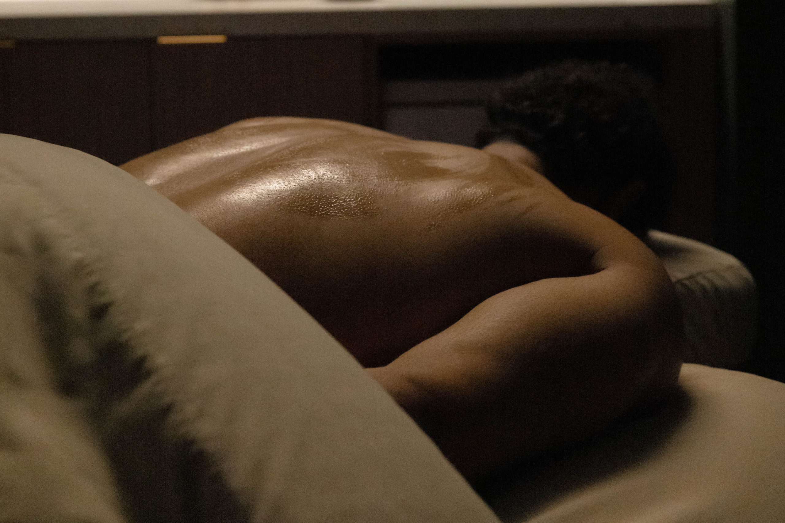 Person receiving a massage on a treatment table in a wellness spa, showcasing a serene atmosphere and relaxation.