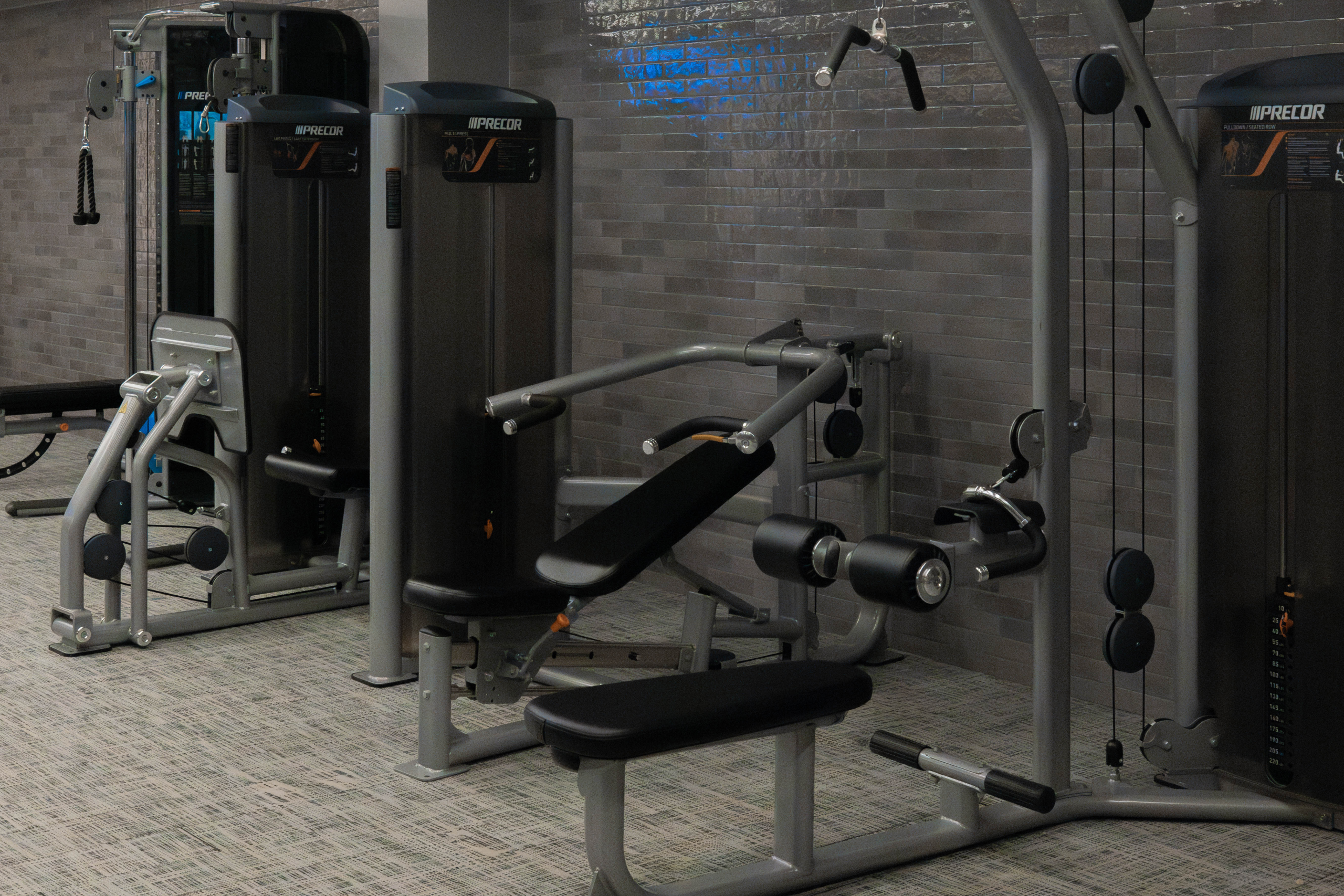 Fitness equipment in a modern gym setting at Exhale Spa, featuring weight machines and a sleek design, emphasizing wellness and fitness programs.