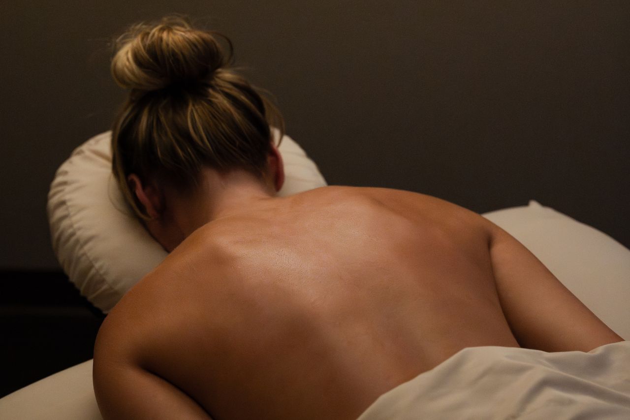Woman receiving a massage in a serene spa setting, emphasizing relaxation and wellness at Exhale Spa in Boston.