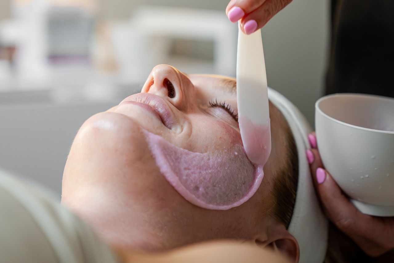 Facial treatment in progress at Exhale Spa, featuring a client receiving a skincare mask application with a spatula, emphasizing wellness and rejuvenation.
