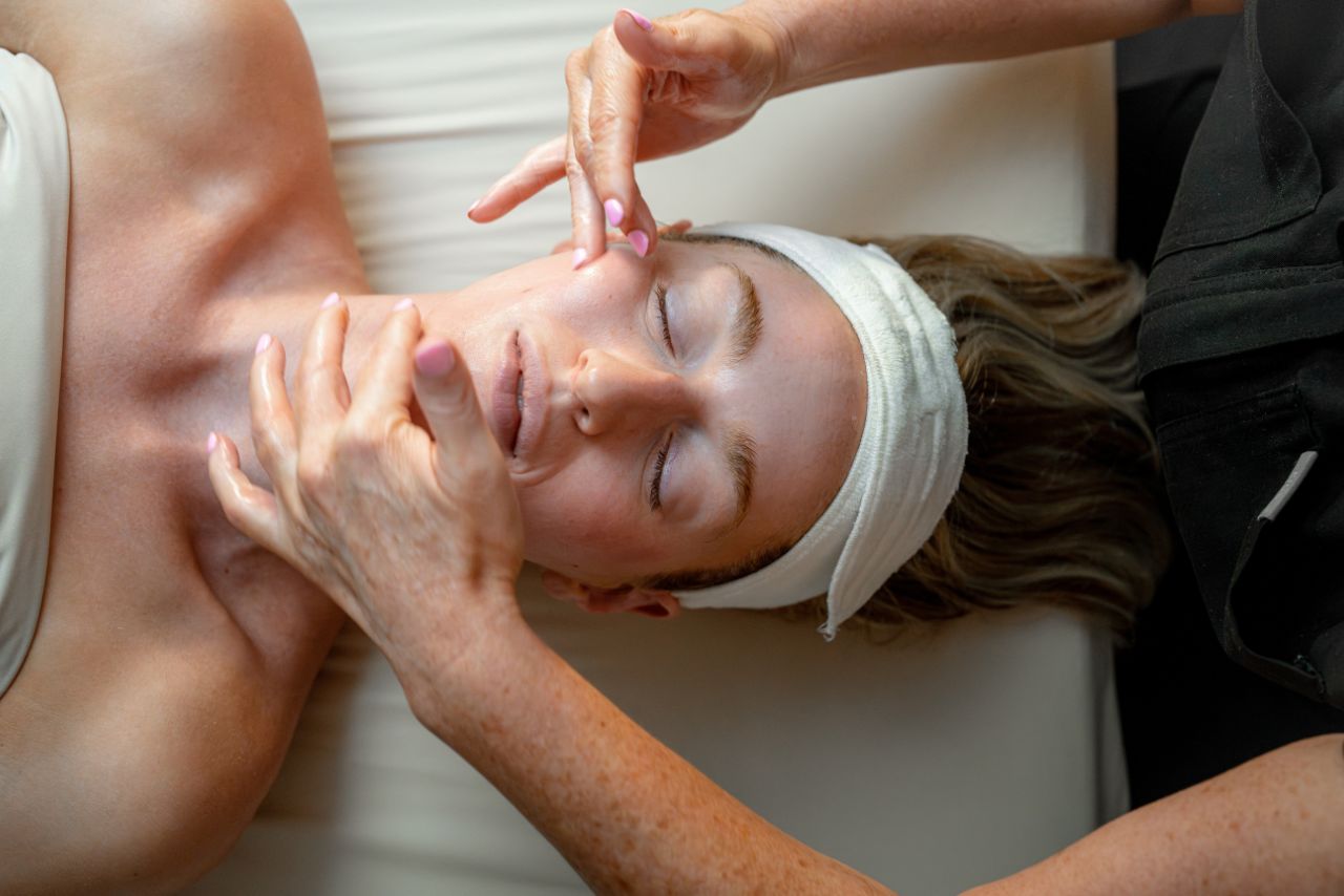 Woman receiving facial treatment at a luxury wellness spa, showcasing expert skincare techniques in a serene environment, emphasizing rejuvenation and relaxation.