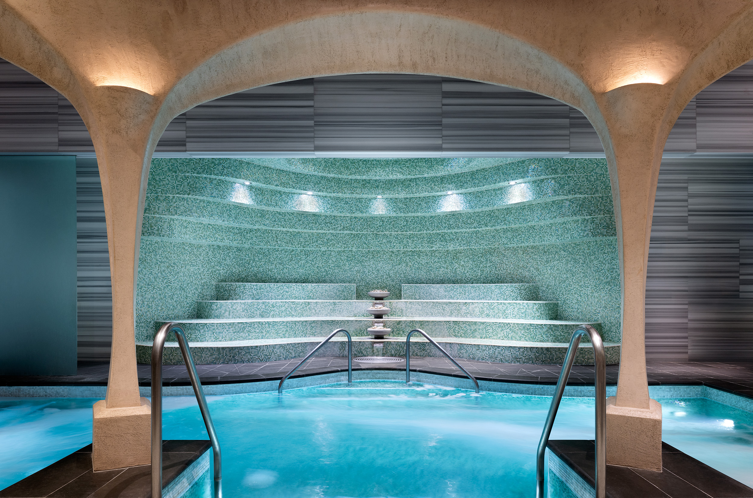 Luxurious spa interior featuring a tranquil soaking pool, mosaic-tiled walls, and ambient lighting, emphasizing relaxation and wellness at Exhale Spa in Atlantic City.