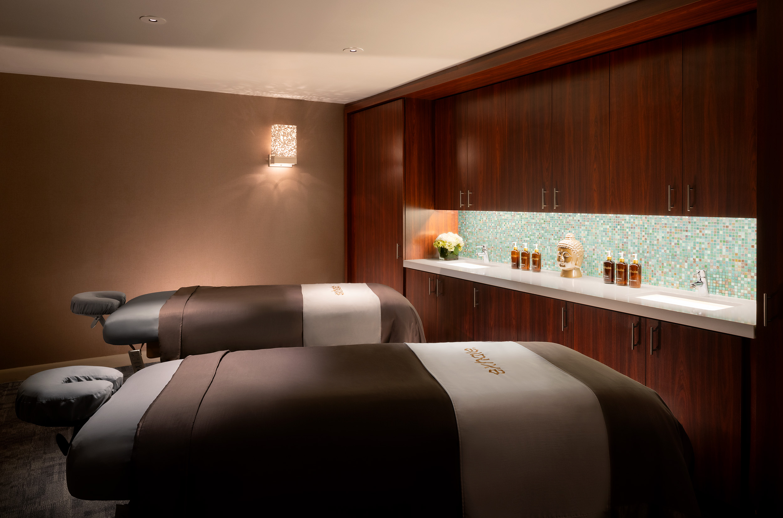 Spa treatment room with two massage tables, elegant decor, and wellness products, reflecting Exhale Spa's focus on relaxation and rejuvenation in Atlantic City.